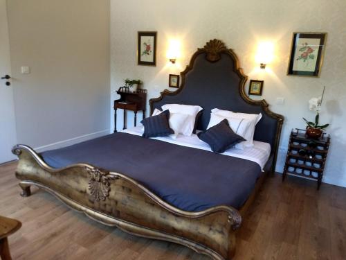a bedroom with a large bed with a large wooden headboard at B&B De Vossenbarm in Jabbeke
