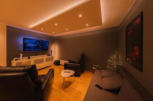 un soggiorno con divano e TV a schermo piatto di Smart Luxury - Private Gym, Hot Tub & Sauna a Keflavík