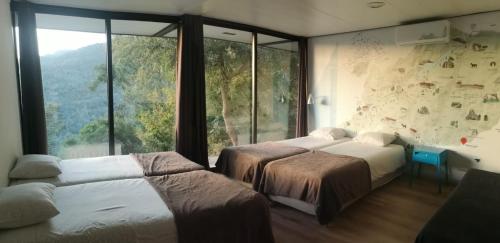 ヴィエイラ・ド・ミーニョにあるSorte das Gestaçasのベッドルーム1室(ベッド2台、大きな窓付)