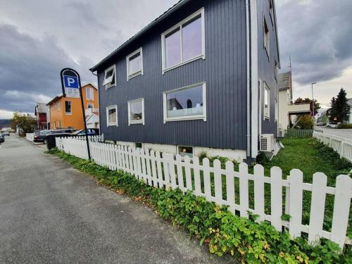 una casa negra con una valla blanca en Sentral leilighet, nært tog, buss, sykehus og byen, en Bodø
