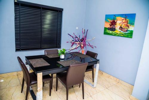 a dining room with a black table and chairs at Jimms Place in Owerri