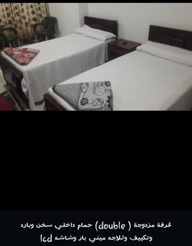 dos camas sentadas una al lado de la otra en una habitación en فندق المهندس, en Al Khārijah