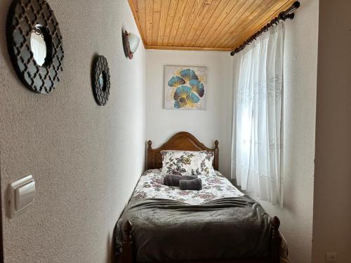 1 dormitorio con cama con almohada y ventana en Dreams in Xisto, en Piódão