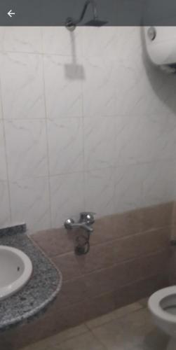 uma casa de banho com um WC e um lavatório em فندق المهندس em Al Khārijah