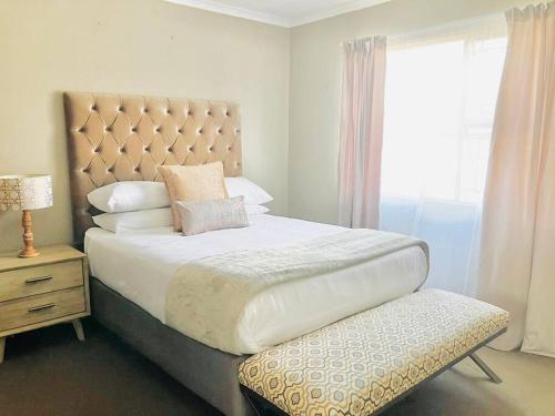 a bedroom with a large bed and a window at ThangoRes in Midrand