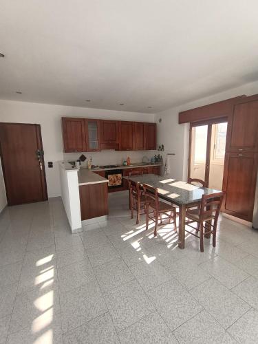 a kitchen with a table and wooden cabinets and a table and chairs at Vista Monte Retreat in Reggio di Calabria