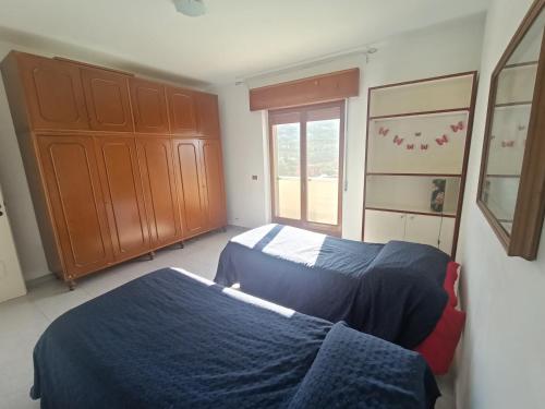 a bedroom with two beds and a window at Vista Monte Retreat in Reggio Calabria