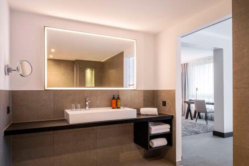 a bathroom with a sink and a mirror at Scandic Nürnberg Central in Nuremberg