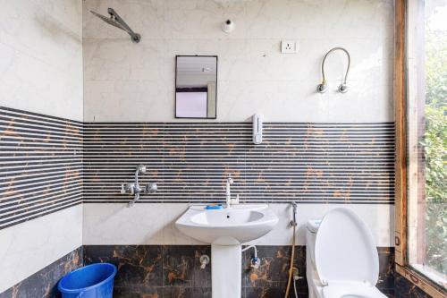 a bathroom with a toilet and a sink at MountArawaliHills in Bhundsi