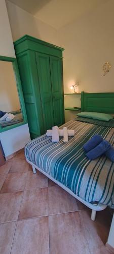a bedroom with a bed with a green headboard at Casa Corone in Alfedena