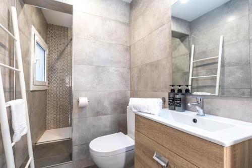ein Badezimmer mit einem weißen Waschbecken und einem WC in der Unterkunft Picasso Suites Cornellá 2.2 in Cornellà de Llobregat