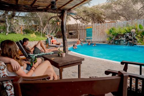 a group of people sitting in chairs by a swimming pool at Rochabus in Ica