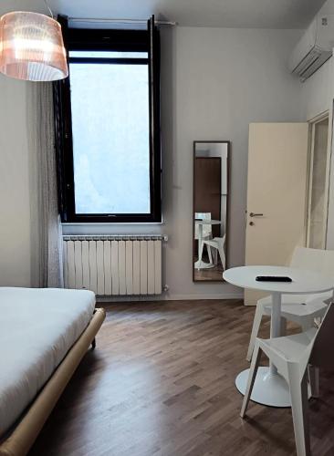 a bedroom with a bed and a table and a window at Stella CasaBono in Sulmona