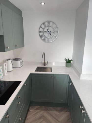 a kitchen with a sink and a clock on the wall at Savannah Lodge in Weymouth