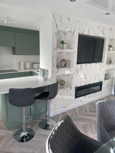 a kitchen with a counter and a tv on a wall at Savannah Lodge in Weymouth