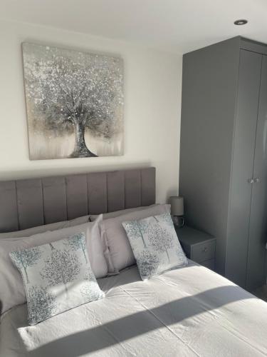 a bedroom with a bed with a tree painting on the wall at Savannah Lodge in Wyke Regis