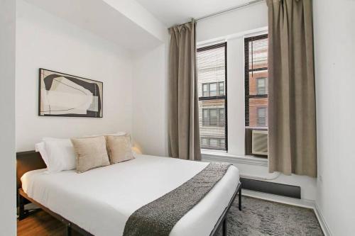 1 dormitorio con 1 cama y 2 ventanas en 2BR Comfy and Roomy Apt in Chicago - Del Prado 1013 en Chicago
