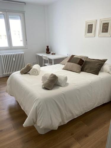 ein Schlafzimmer mit einem großen weißen Bett mit Kissen in der Unterkunft Leonmisol in León