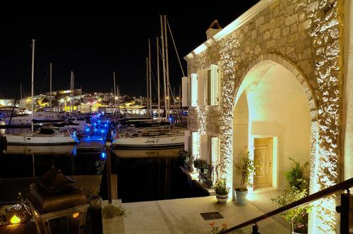 un port de plaisance de nuit avec des bateaux dans l'eau dans l'établissement Cesme Marina Konukevi, à Çeşme