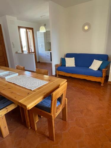 uma sala de estar com uma mesa e um sofá azul em TALAhome27 em Alghero