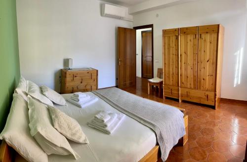 um quarto com uma cama grande e um armário de madeira em TALAhome27 em Alghero