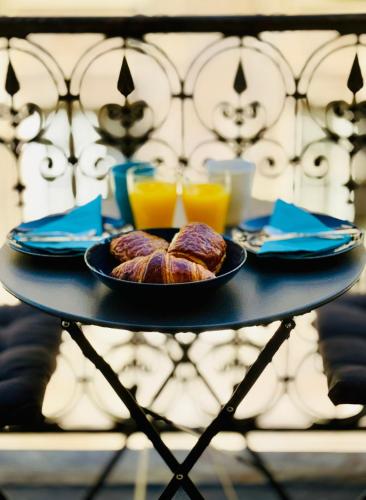une table avec deux assiettes de nourriture et deux verres de jus d'orange dans l'établissement Cosy Studio with balcony Paris Center - Sorbonne - Pantheon - Notre-Dame, à Paris