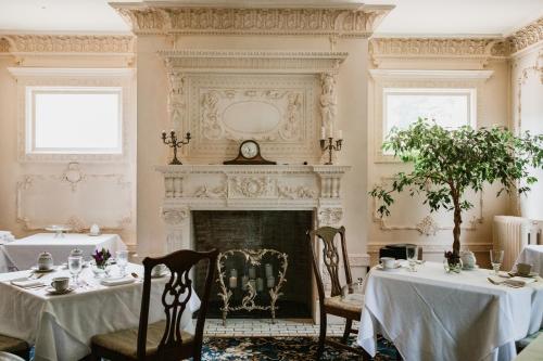 a dining room with two tables and a fireplace at South Shire in Bennington