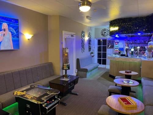 a room with a bar with a couch and tables at Clifton Private Hotel in Blackpool