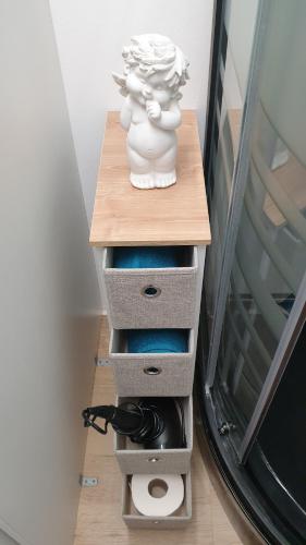 a stack of drawers with a statue on a table at Studio in Sempachersee in Hildisrieden