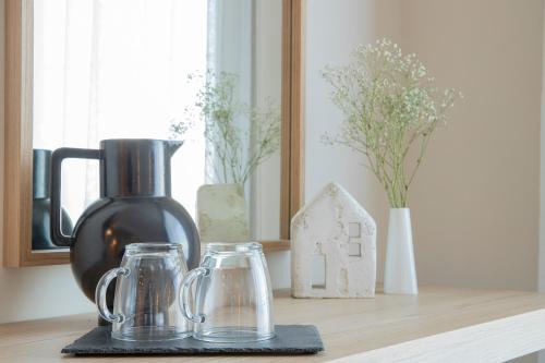 a kitchen counter with a black vase and two glass jars at Zefyros Sea View Hotel in Platamonas