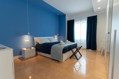 a blue bedroom with a bed with a blue wall at L'Onda Affittacamere in Civitavecchia