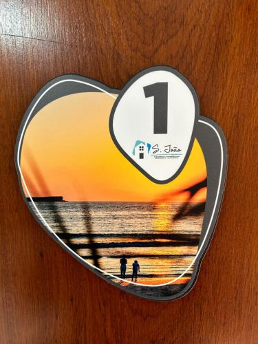 a heart shaped sign with a picture of the beach at Alojamento S. João in Peniche