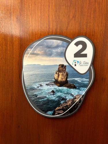 a sign with a picture of a rock in the ocean at Alojamento S. João in Peniche