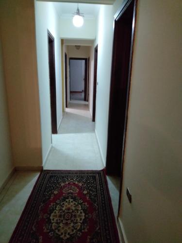 - un couloir avec un tapis à l'étage, à côté d'une porte dans l'établissement التجمع الخامس القاهره الجديده الحي الخامس المنطقة الثانية شارع 16 فلا 142, au Caire