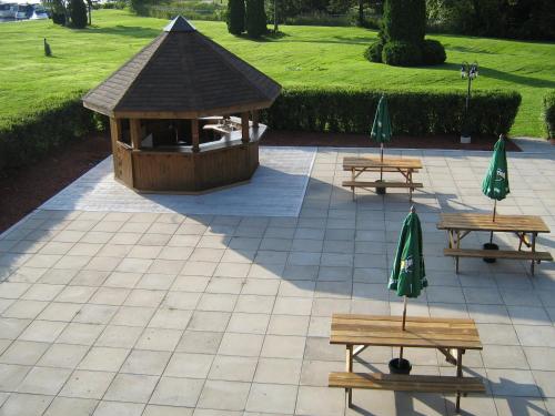 two picnic tables and a gazebo in a park at Ramada by Wyndham Belleville Harbourview Conference Center in Belleville