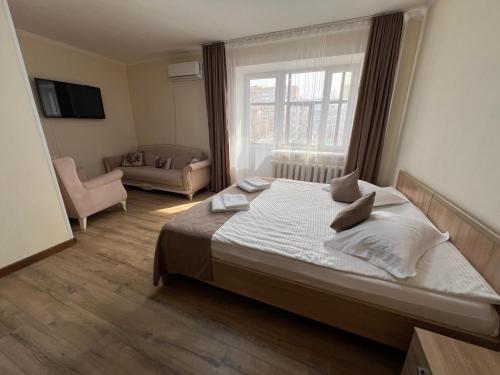 um quarto com uma cama, uma cadeira e uma janela em Belon inn em Astana