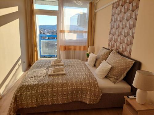a bedroom with a large bed with a window at BB Panorama apartman in Budapest
