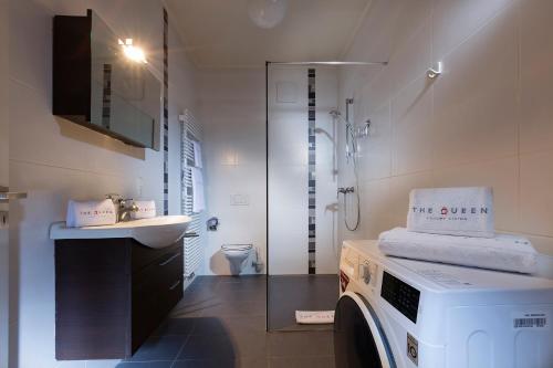 a bathroom with a washing machine and a sink at Villa Doria in Luxembourg
