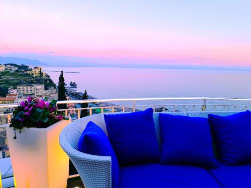 Sofá azul sentado en un balcón con vistas al océano en Aquaboutique Wellness&Spa, en Vietri