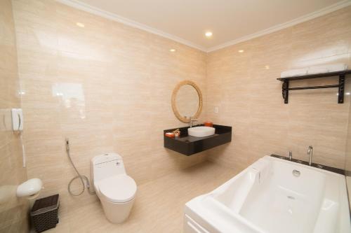 a bathroom with a white toilet and a sink at The Light Hotel in Nha Trang