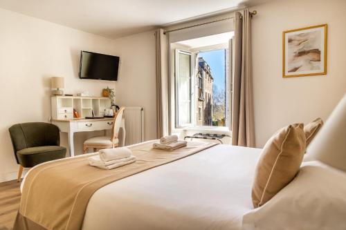 een slaapkamer met een groot wit bed en een raam bij Demeures & Châteaux - Hôtel De La Porte Saint-Malo in Dinan