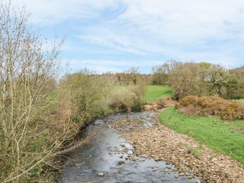 a stream in a field with trees and a sky at Skipper in Lancaster