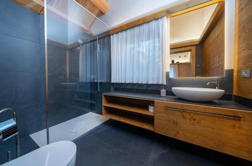 uma casa de banho com um lavatório e um espelho em Kile Alpine Resort em Valbruna