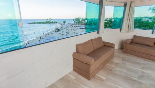 sala de estar con silla y vistas a la playa en Home Superior Nascer do Sol en Cairu