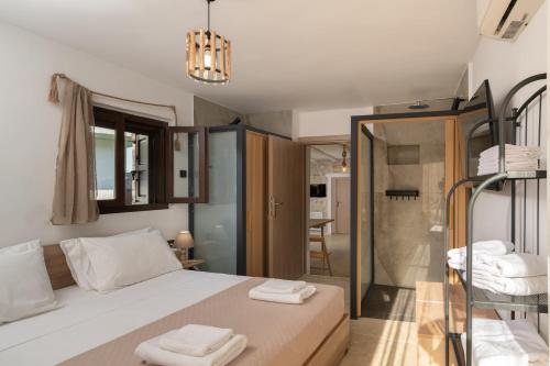 a bedroom with a bed and a glass shower at Treasure of Herbs Complex in Panormos Rethymno