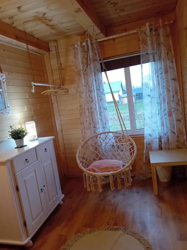 um baloiço num quarto com uma janela em Wróblówka- domek na wsi em Parczew