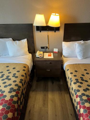 um quarto de hotel com duas camas e uma mesa de cabeceira em Red Carpet Inn Quantico em Dumfries