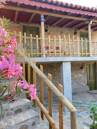 eine Holztreppe, die zu einem Haus mit rosa Blumen führt in der Unterkunft Kalyopi Köy Evi in Gokceada Town
