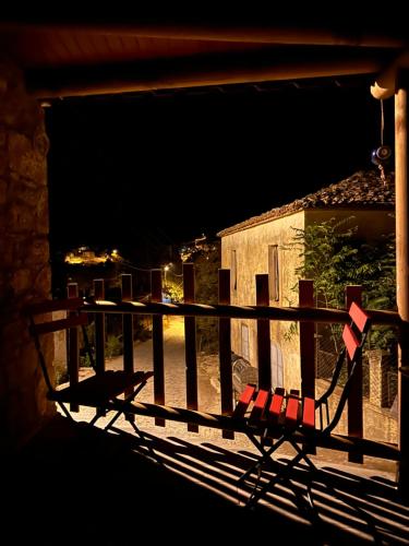 a bench sitting on a balcony at night at Kalyopi Köy Evi in Gokceada Town