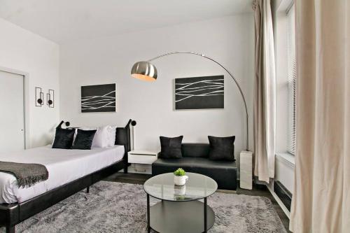 1 dormitorio con cama, mesa y sofá en Serene & Contemporary Studio Apartment - Del Prado 817, en Chicago